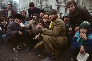 ca. December 1989, Bucharest, Romania --- Soldier Sitting with Crowd --- Image by © David Turnley/CORBIS